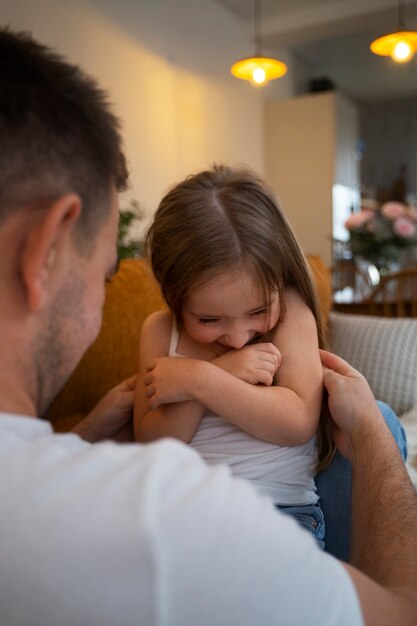 Father making his daughter laugh by tickling her