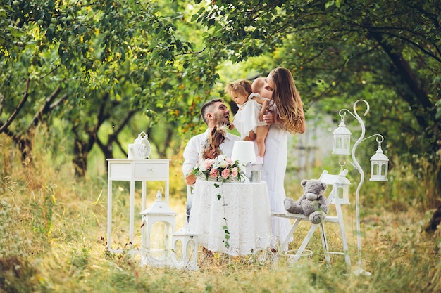 Father, mother and daughter together at the picnic in the garden