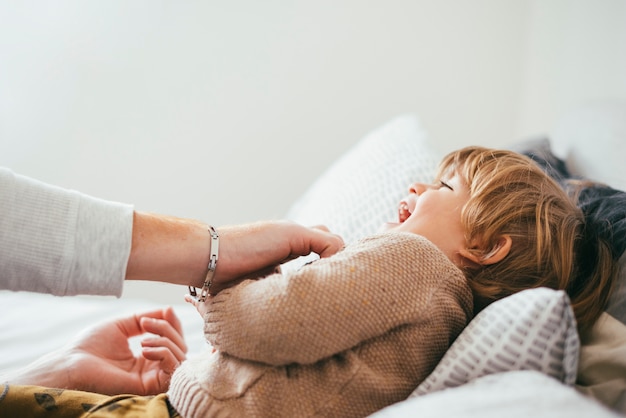 Free photo father playing with child on bed