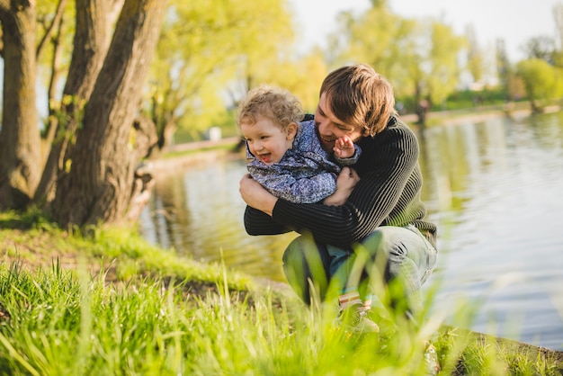 Free photo father playing with his son by the lake