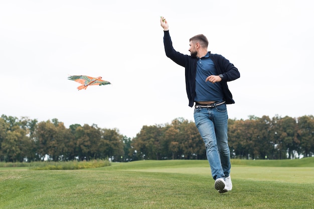 Father playing with a kite in park