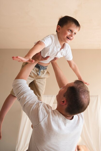 Father playing with toddler indoors