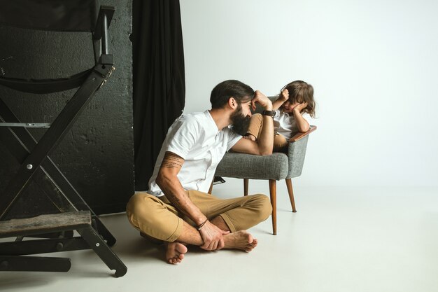 Father playing with young son in their sitting room at home.