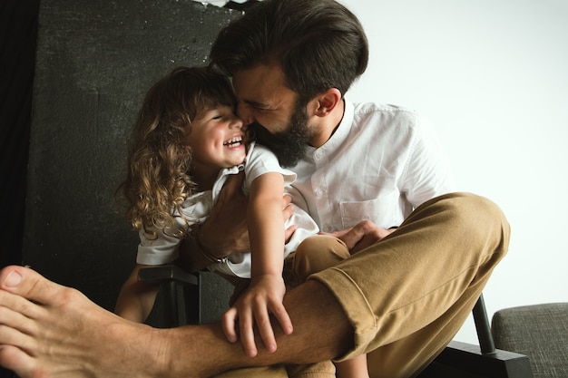 Father playing with young son in their sitting room at home