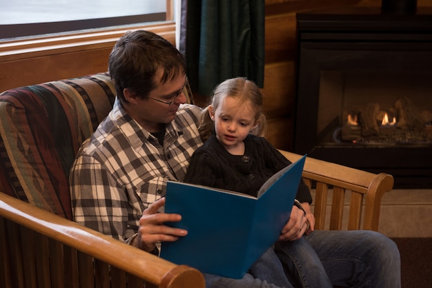 Free photo father reading story book to daughter