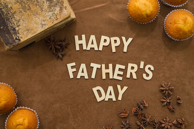 Free photo father's day surface with vintage book and tasty muffins