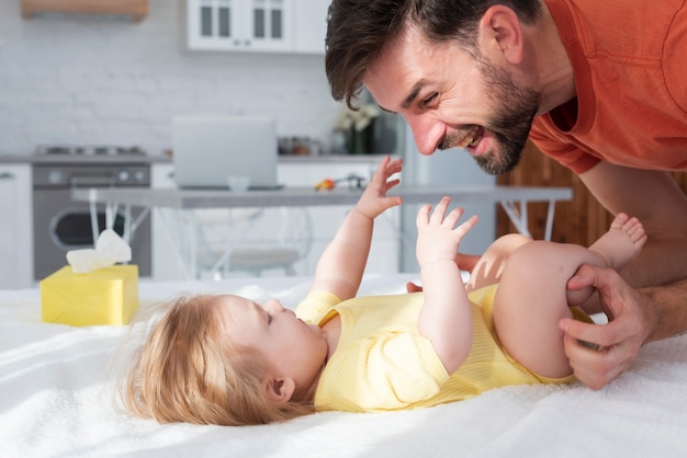 Father smiling and playing with baby