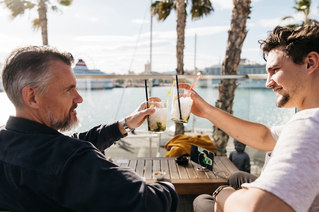 Free photo father and son drinking cocktail