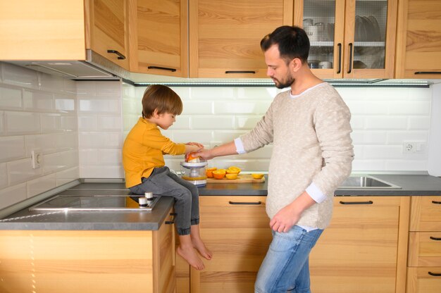 Father and son in the kitchen making a juice