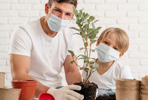 Free photo father and son learning about planting together at home