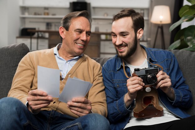 Father and son looking at photos in living room