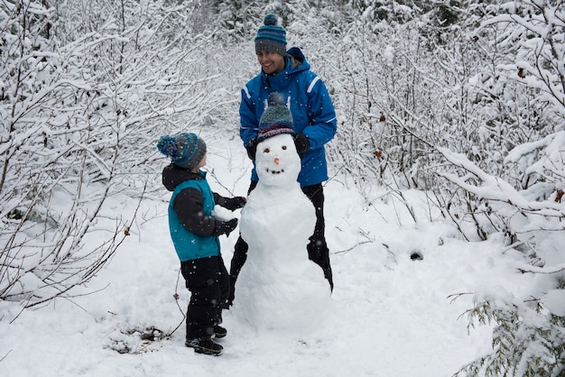 Free photo father and son making snowman