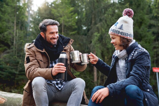 Father and son making a toast in the forest