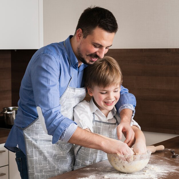 Father and son making together dough