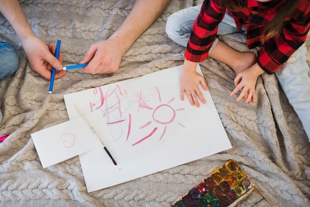 Father and son painting with crayons