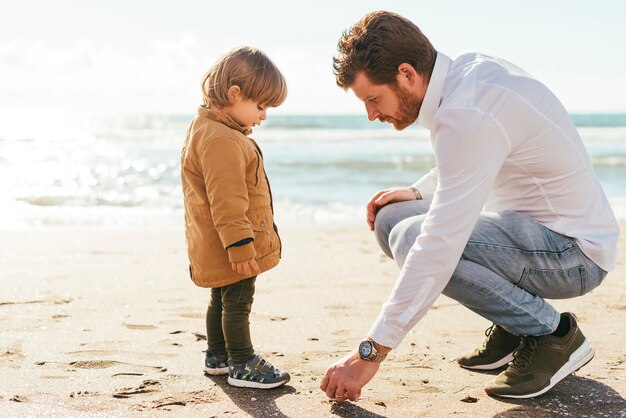 Father and son picking up pebble