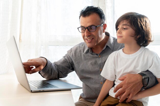 Father and son playing something on a laptop