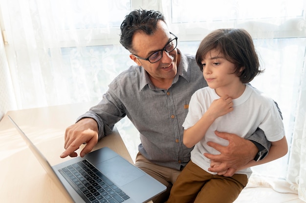 Father and son playing something on a laptop