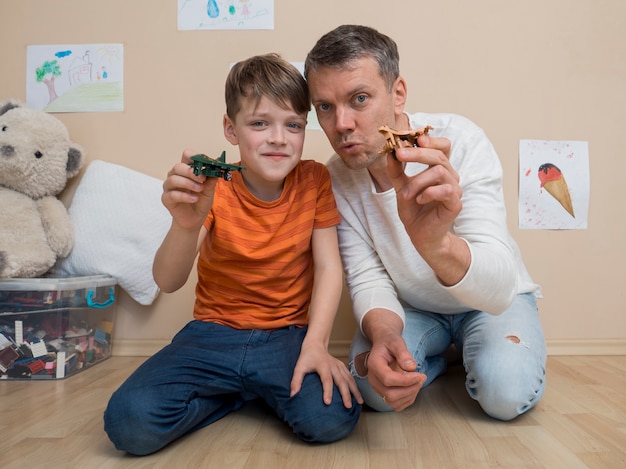 Father and son plying with plane toys