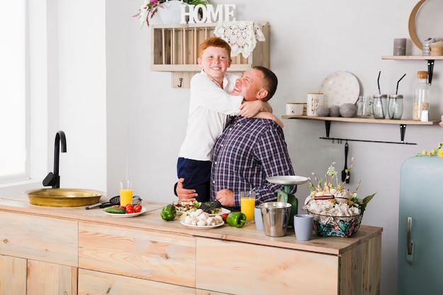 Free photo father and son posing in the kitchen