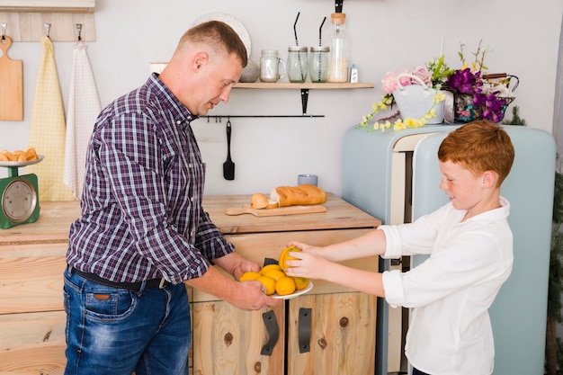 Free Photo father and son posing in the kitchen