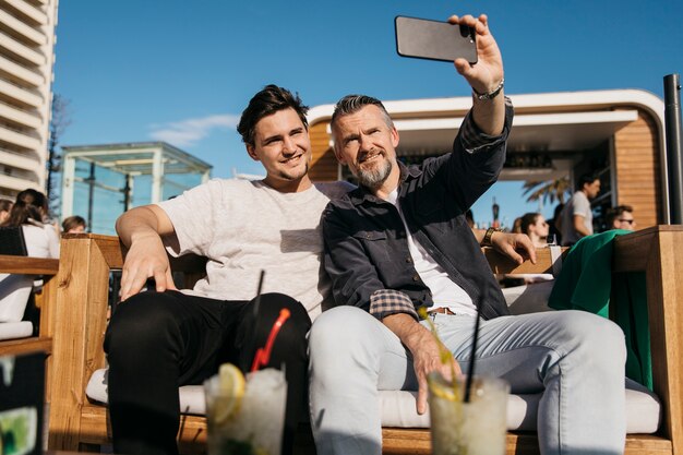 Father and son taking selfie in bar