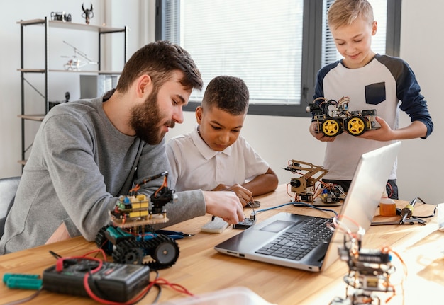 Free Photo father and sons making robot