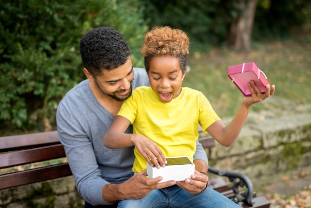 Father surprising his little girl with a new mobile phone