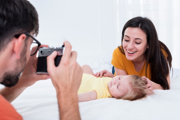 Father taking picture of mother with baby