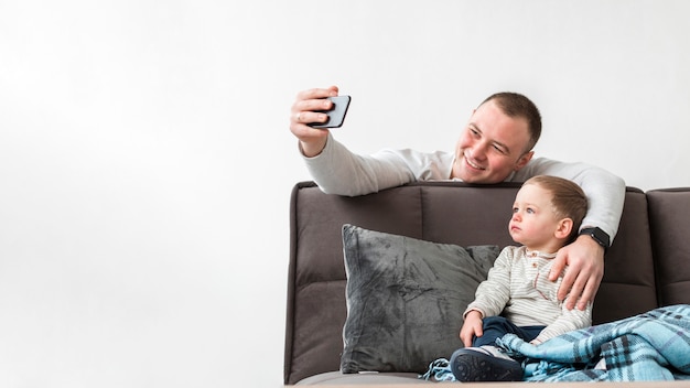 Free Photo father taking a selfie with his baby