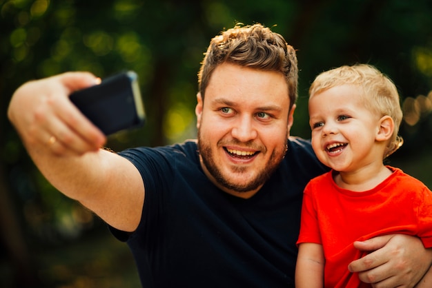 Free Photo father taking a selfie with his son