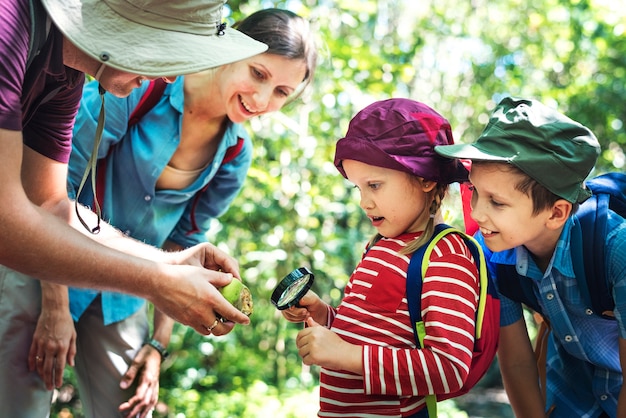 Free photo father teaching his daughter how to use a magnifying glass