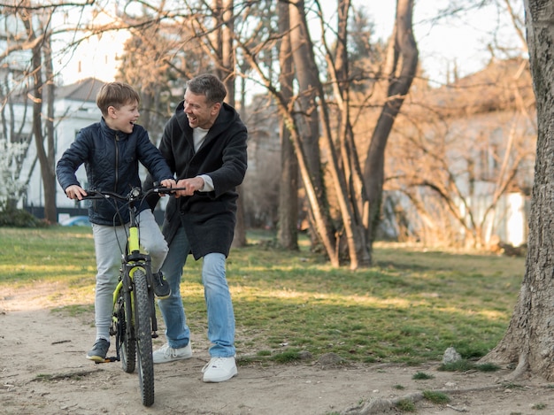 Father teaching his son how to ride a bike long view