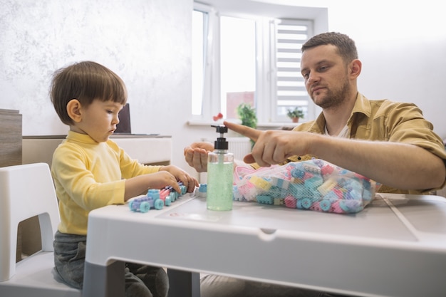 Father using hand sanitizer on his hands