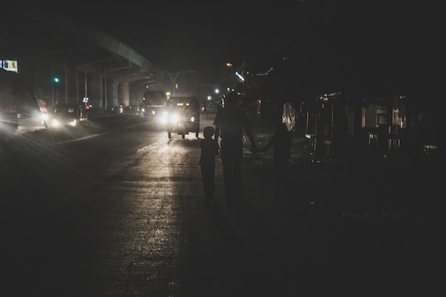 Father walking with his two kids at night in the city