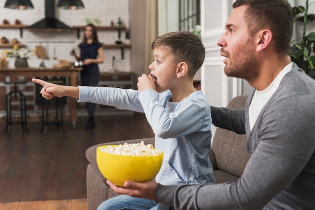 Father watching a movie with son