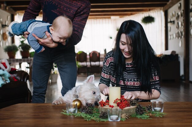 Father with baby in arms while mother lights a candle