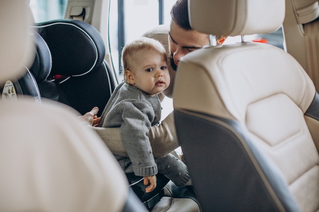 Free photo father with baby daughter in a car showroom