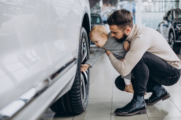 Father with baby daughter in a car showroom