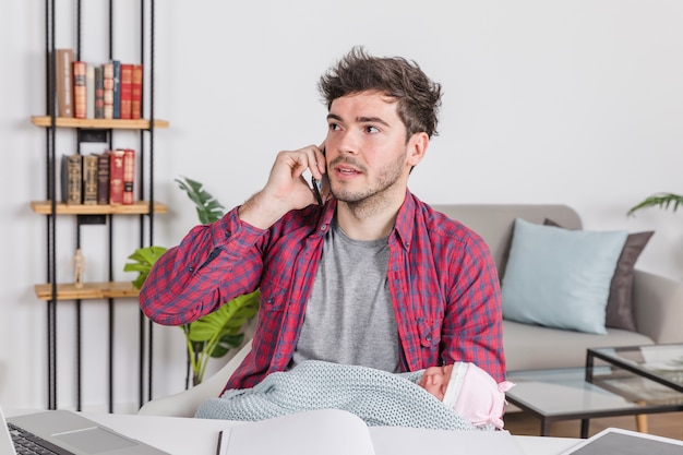 Father with baby talking on phone 