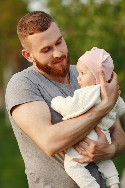 Father with her baby spend time in a summer garden