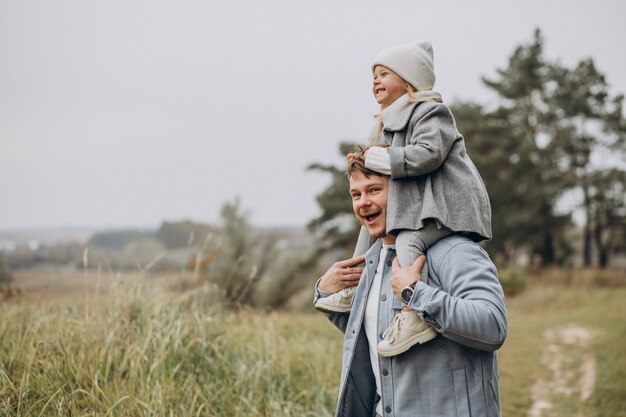 Father with little daughter together in autumnal weather having fun