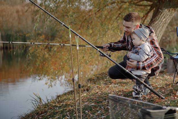 Free Photo father with little son near river in a fishing morning