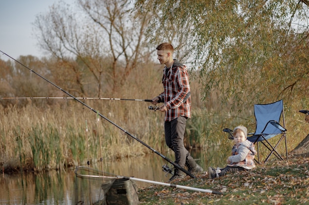 Father with little son near river in a morning fishing