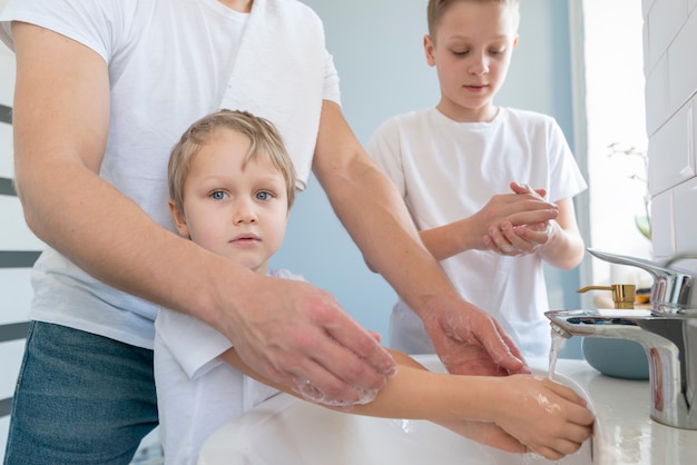 Father with siblings washing hands side view