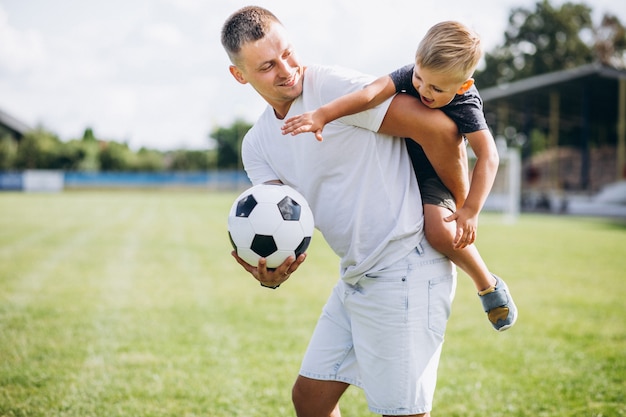 Father with son playing football at the field