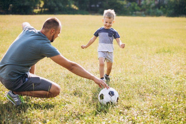 Free photo father with son playing football at the field