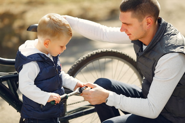 Free Photo father with son repare the bike in a park