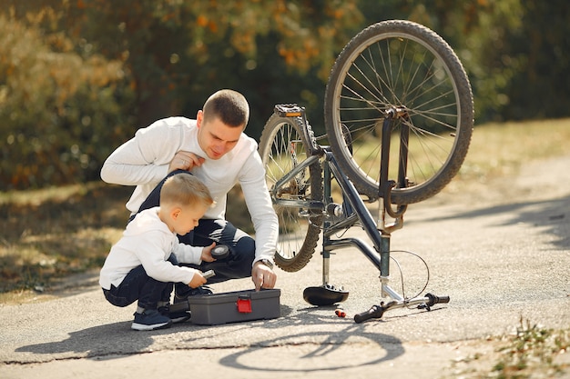 Father with son repare the bike in a park