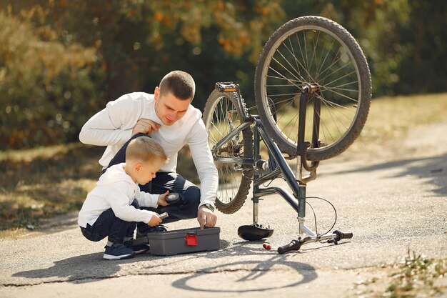 Father with son repare the bike in a park